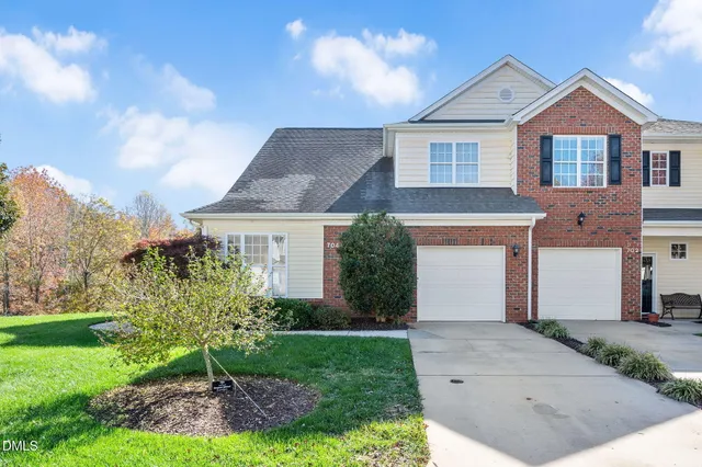 a front view of a house with a yard and trees