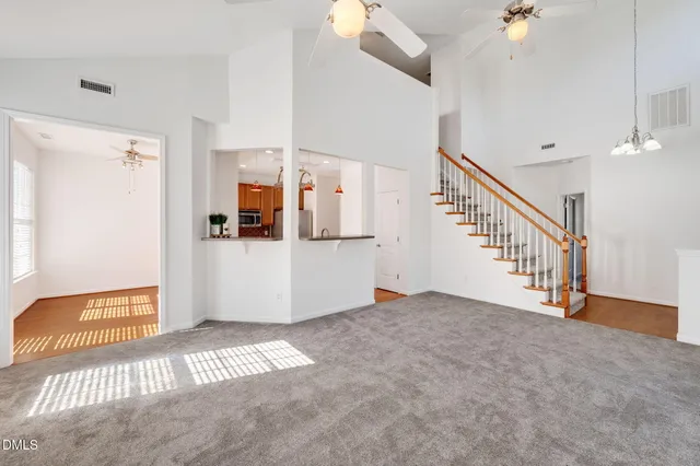an empty room with windows fireplace and fan