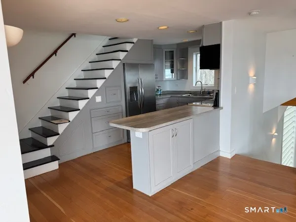 a kitchen with stainless steel appliances granite countertop a sink counter space and wooden floor