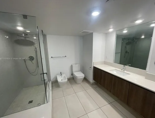 a bathroom with a double vanity sink toilet and shower