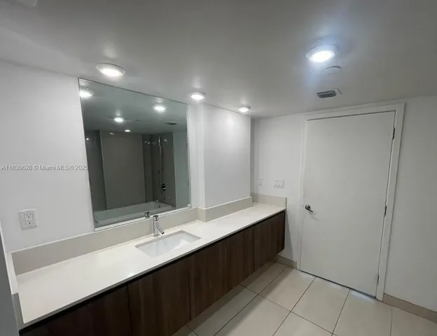 a bathroom with a double vanity sink and a mirror