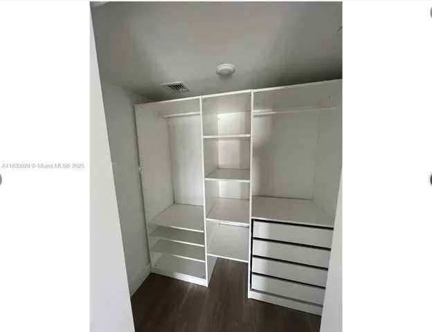 a view of walk in closet with empty racks