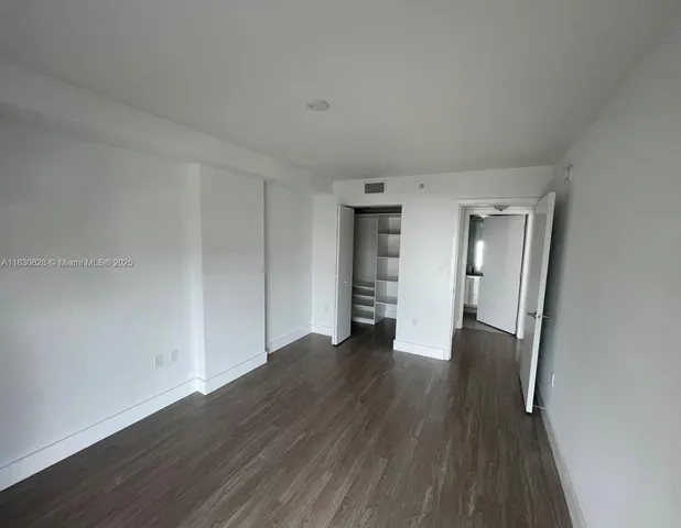 an empty room with wooden floor and closet