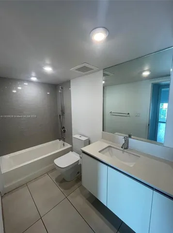 a bathroom with a double vanity sink toilet and a bathtub