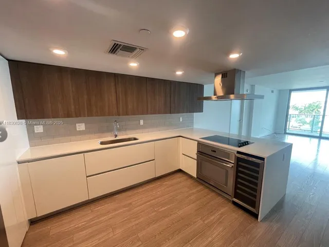 a kitchen with wooden floors and white stainless steel appliances