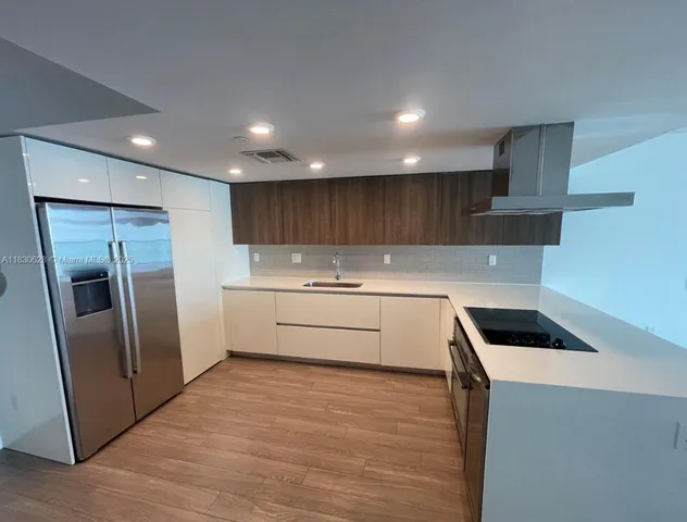 a kitchen with a refrigerator sink and cabinets