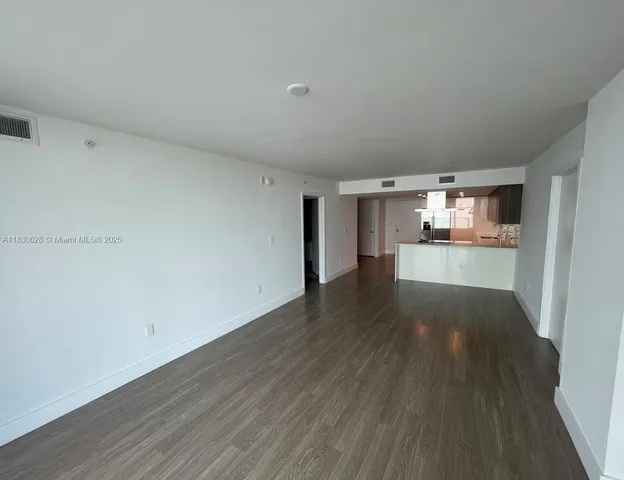 a view of a kitchen with wooden floor and windows