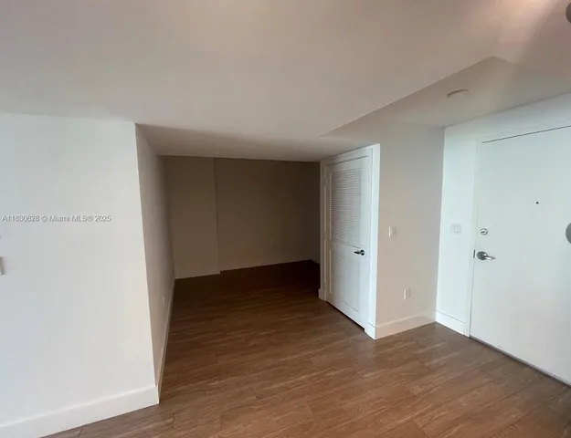 a view of an empty room and wooden floor