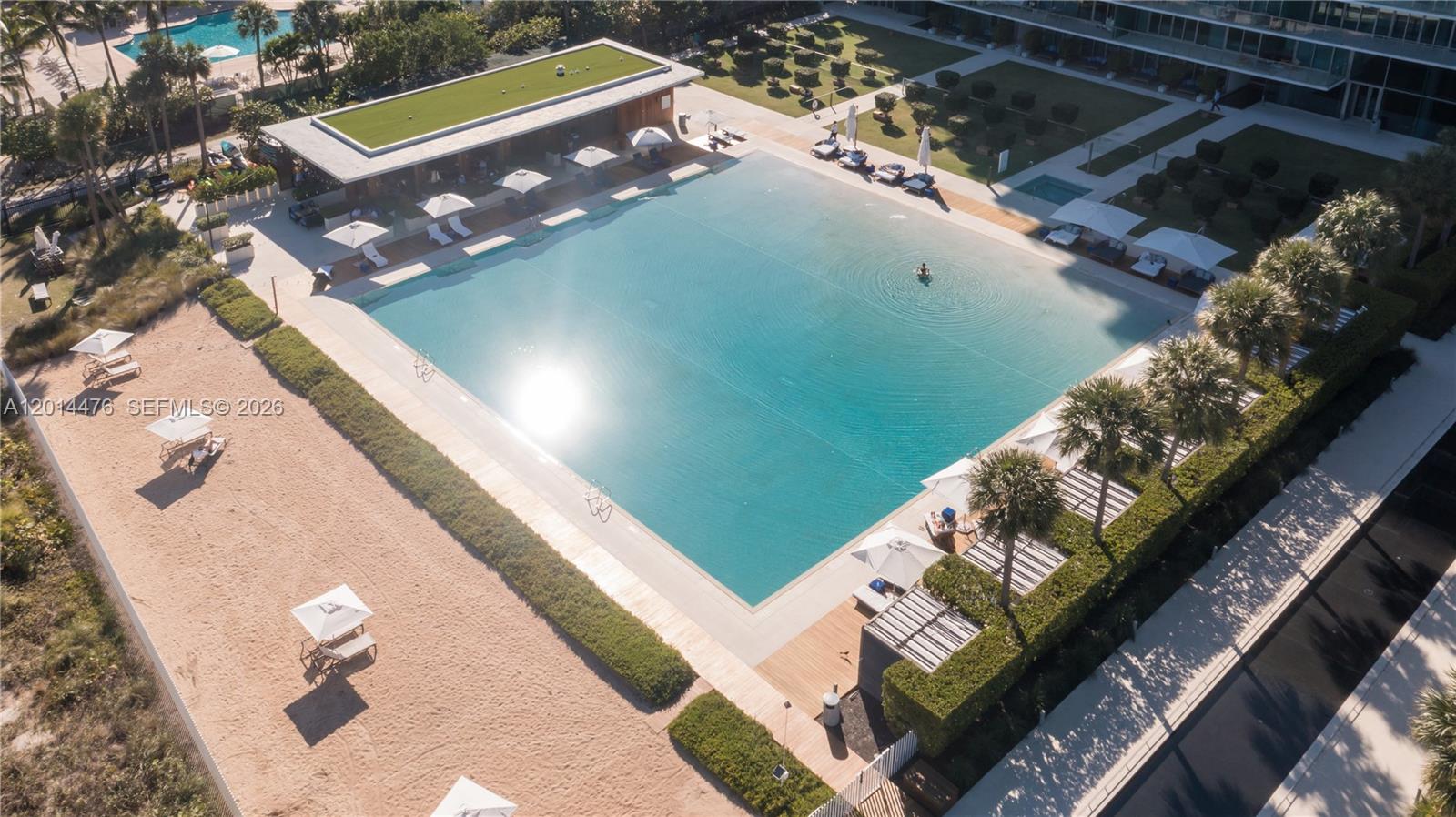 360 Ocean Drive, Unit 1106S Key Biscayne, FL 33149 - Photo 44 of 67 Aerial Pool and Beach View – The main pool deck is framed by cabanas, lounge areas, palms, and the nearby beach. The overhead view highlights the resort-style outdoor setting just steps from the sand.