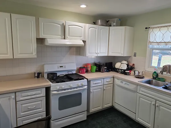 a kitchen with white cabinets and white appliances