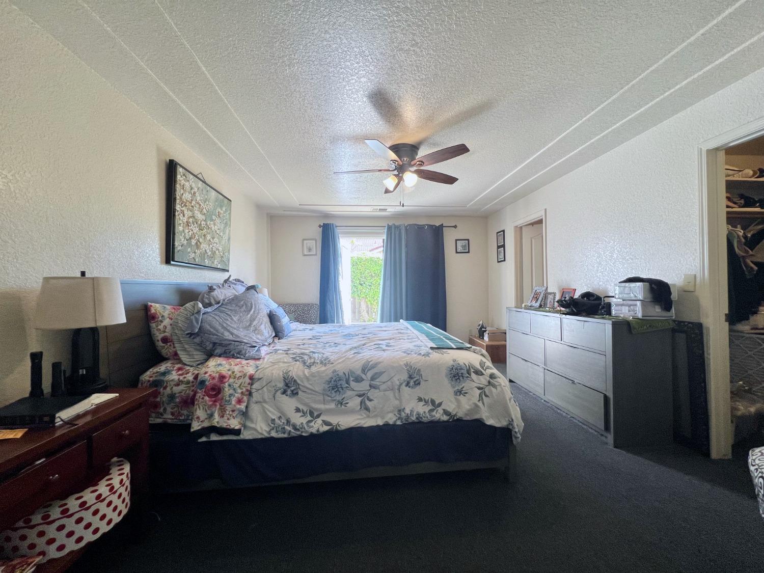 3116 Larrynell Drive Ceres, CA 95307 - Photo 16 of 32 a bedroom with a bed and a chandelier