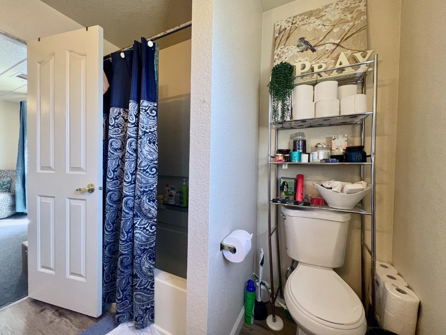3116 Larrynell Drive Ceres, CA 95307 - Photo 19 of 32 a white toilet sitting next to a bathroom sink and a shower