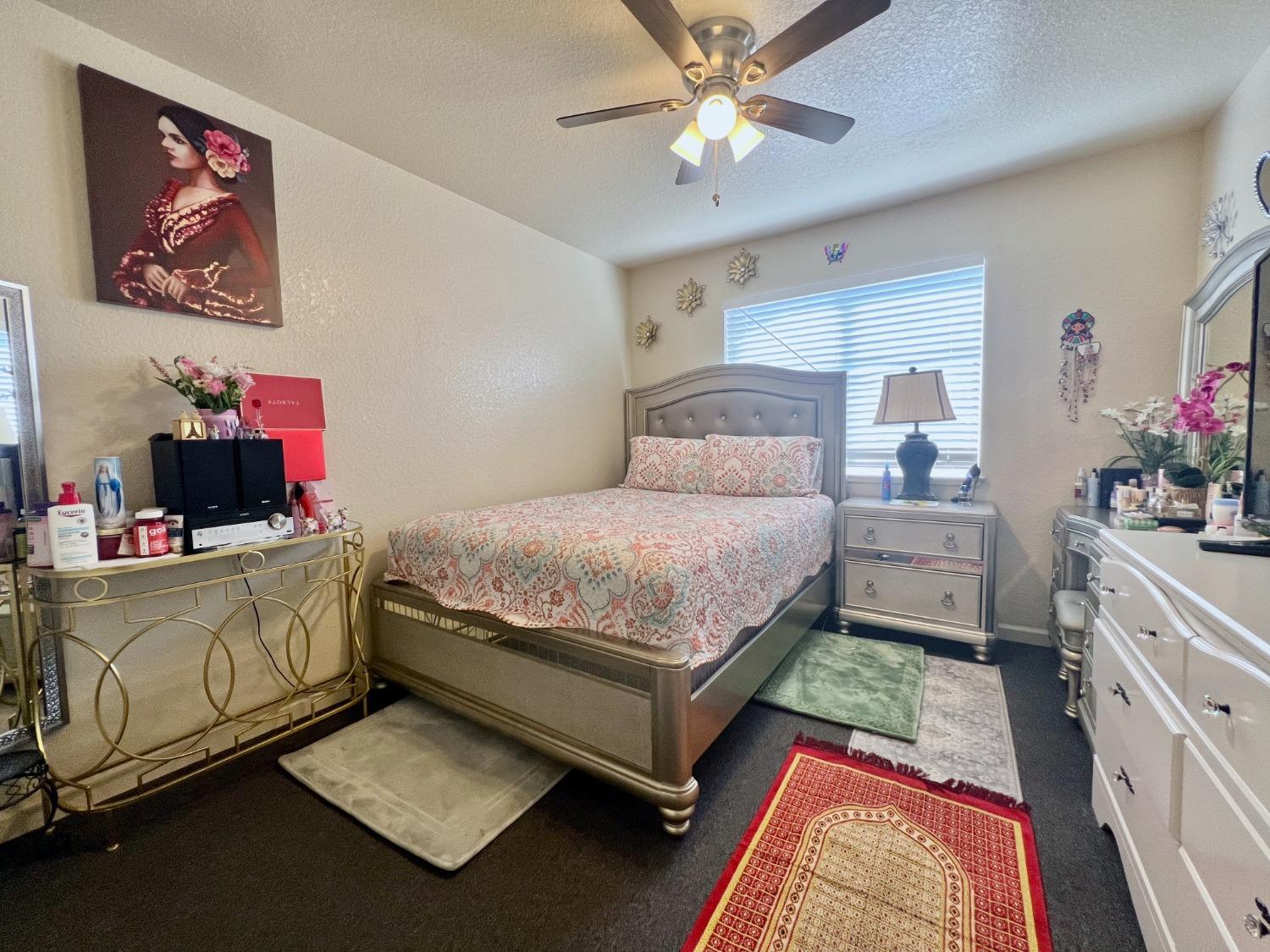 3116 Larrynell Drive Ceres, CA 95307 - Photo 20 of 32 a bedroom with a bed and a chandelier