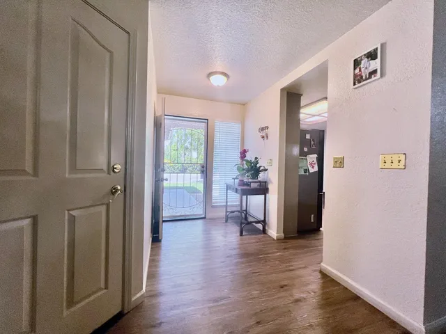 a view of a hallway with bathroom and wooden floor