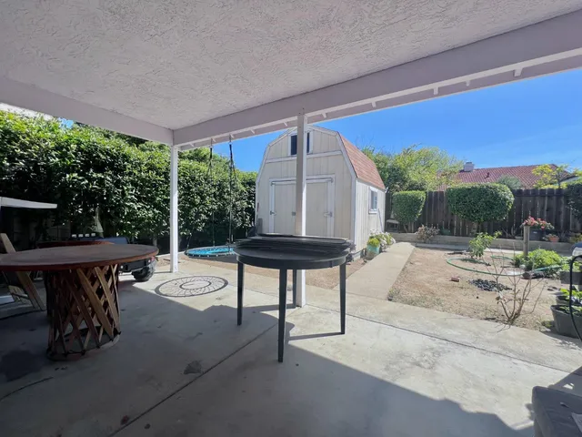 a view of a patio with table and chairs and potted plants