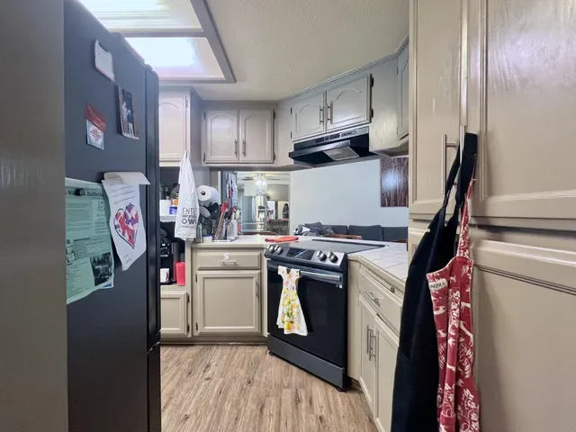 a kitchen with refrigerator and cabinets