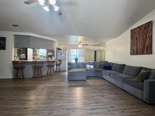 a living room with furniture and a large mirror with wooden floor