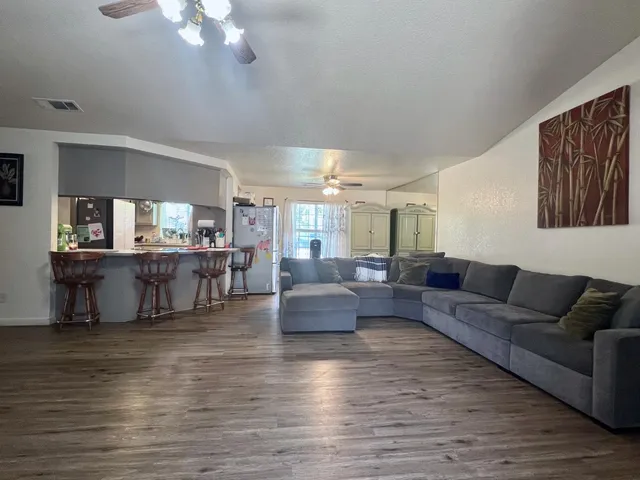 a living room with furniture and a large mirror with wooden floor