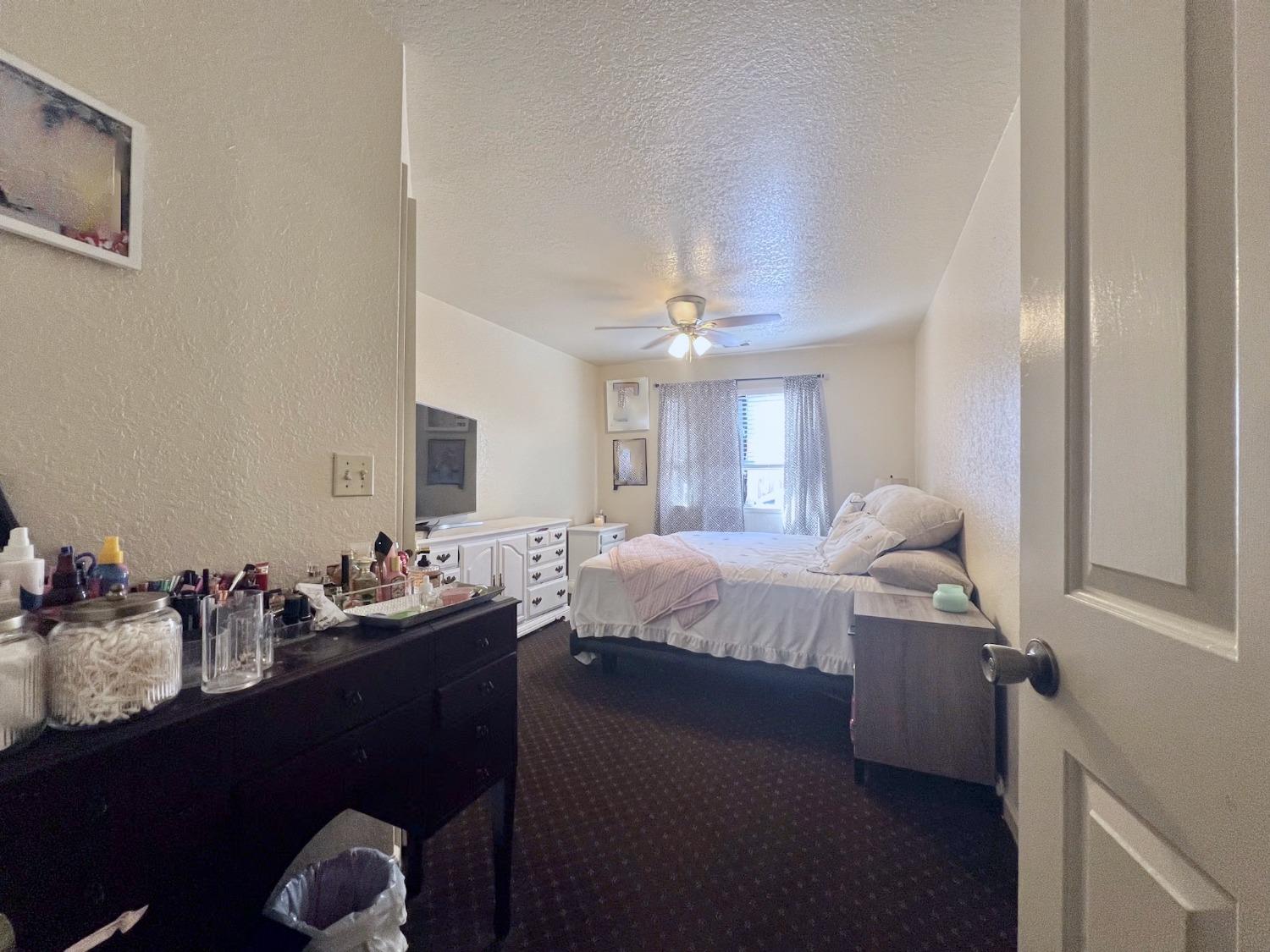 3116 Larrynell Drive Ceres, CA 95307 - Photo 10 of 32 a spacious bedroom with a bed and a chandelier