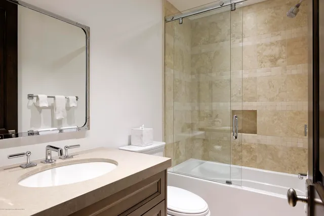 a bathroom with a granite countertop sink toilet and shower