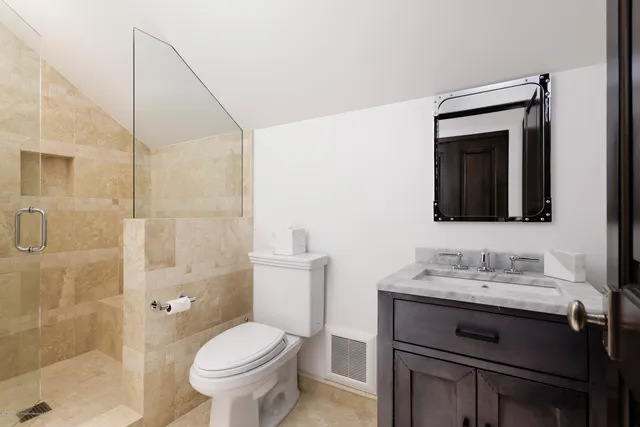 a bathroom with a granite countertop sink toilet and shower