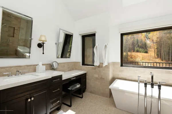 a bathroom with a large tub sink and mirror