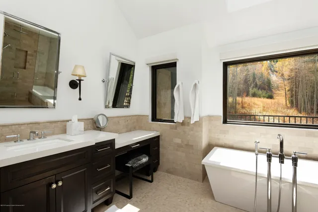 a bathroom with a large tub sink and mirror