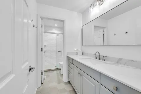 a bathroom with a double vanity sink mirror and shower