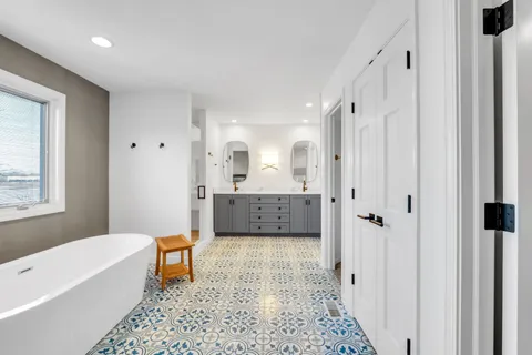 a bathroom with a tub shower vanity and a sink
