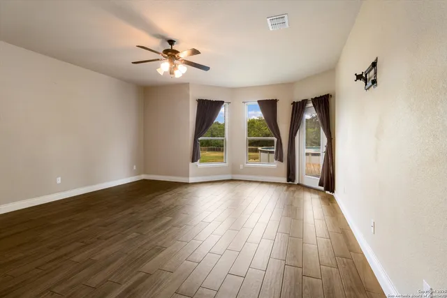 wooden floor in an empty room with a window