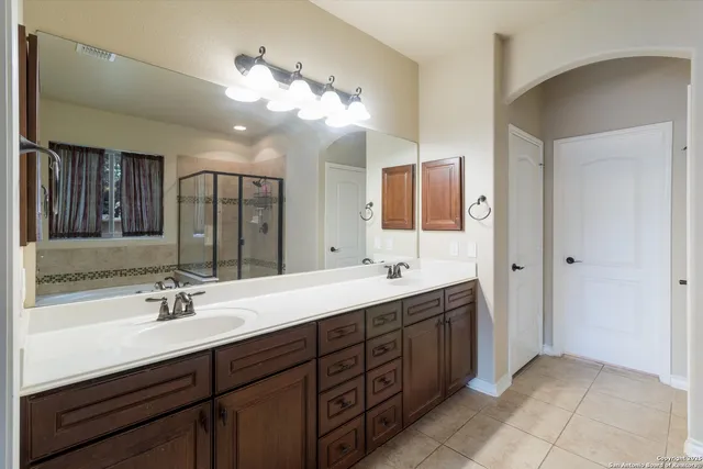 a bathroom with a sink double vanity granite and a mirror