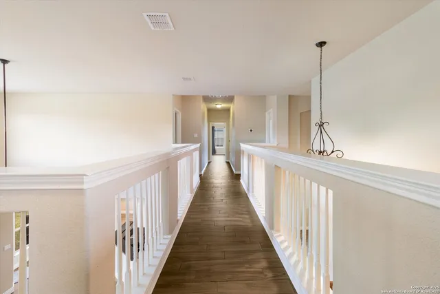 a view of a hallway with wooden floor and stairs