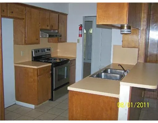 a kitchen with stainless steel appliances granite countertop a refrigerator a stove and a sink