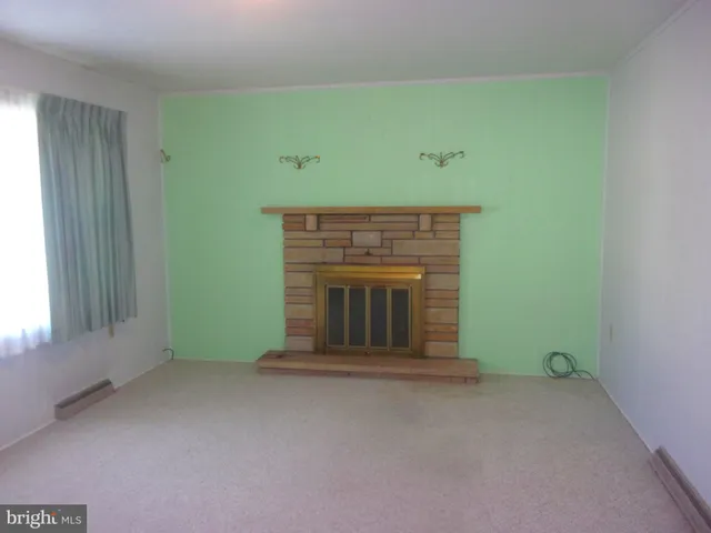 a view of an empty room with a fireplace