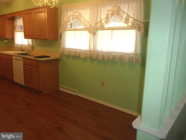 a kitchen with a window wooden floor and a sink