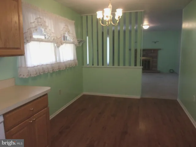 en empty room with windows and chandelier