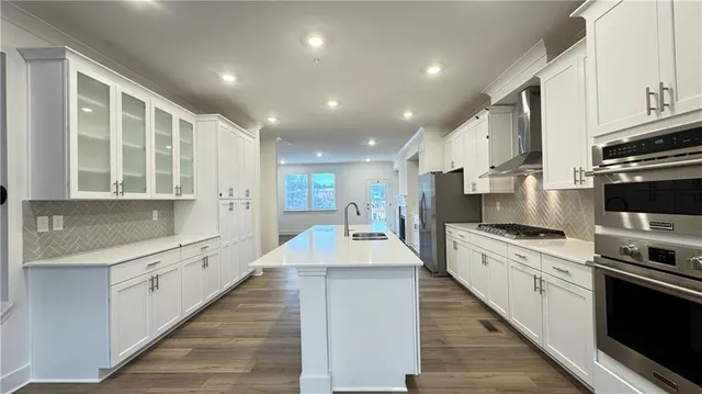 a large kitchen with stainless steel appliances lots of counter space and wooden floor