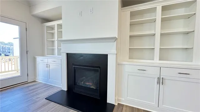 a view of an empty room with a fireplace and a window