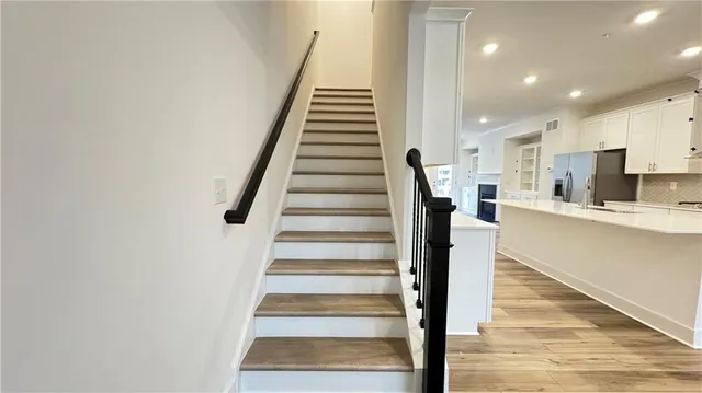 a view of a hallway with wooden floor and staircase