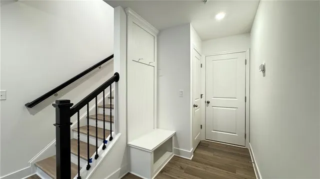 a view of a hallway with wooden floor and staircase