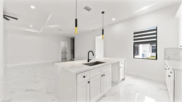a view of a kitchen island a sink a counter space and a window