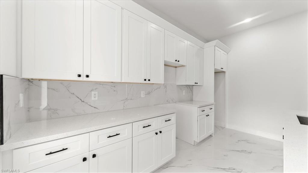 766 Roma Avenue South Lehigh Acres, FL 33974 - Photo 16 of 50 a kitchen with white cabinets and a sink