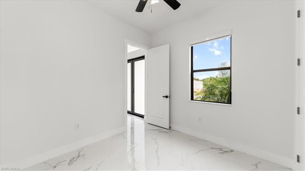 766 Roma Avenue South Lehigh Acres, FL 33974 - Photo 21 of 50 an empty room with windows and fan