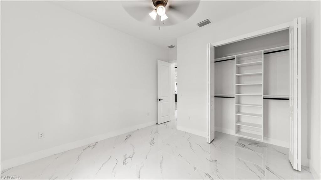 766 Roma Avenue South Lehigh Acres, FL 33974 - Photo 24 of 50 a view of a room with closet and a ceiling fan
