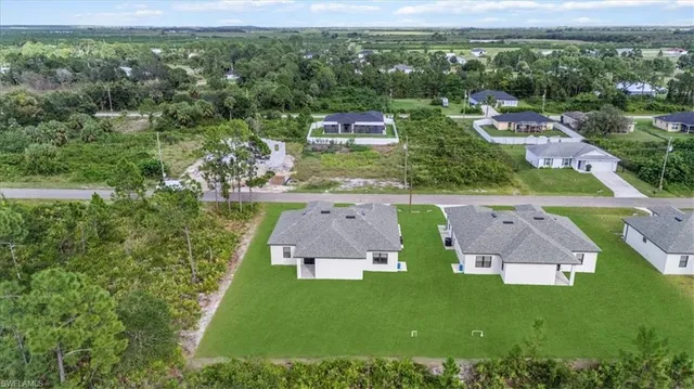 an aerial view of a house with a garden and lake view