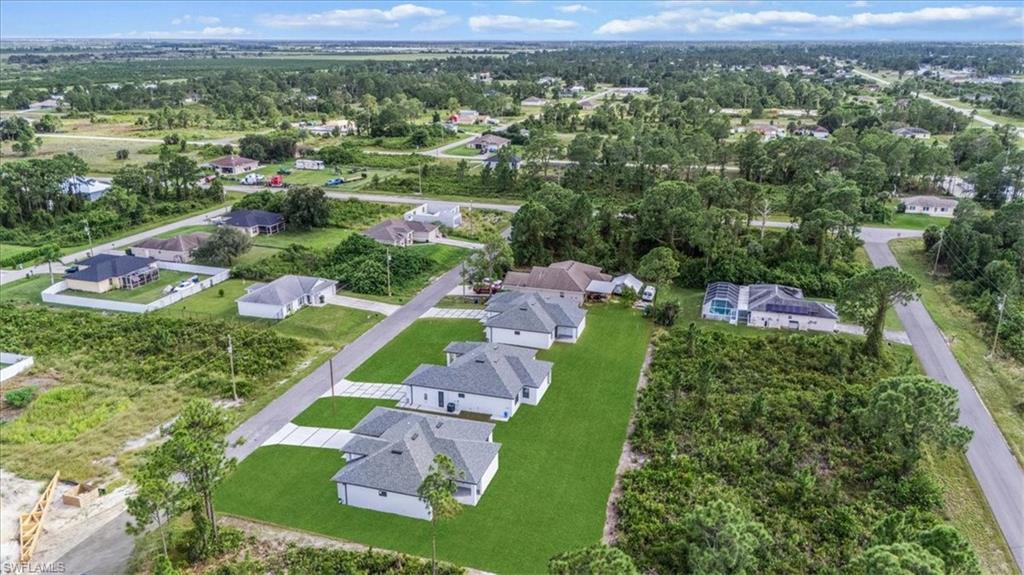 766 Roma Avenue South Lehigh Acres, FL 33974 - Photo 46 of 50 an aerial view of green landscape with trees houses and mountain view