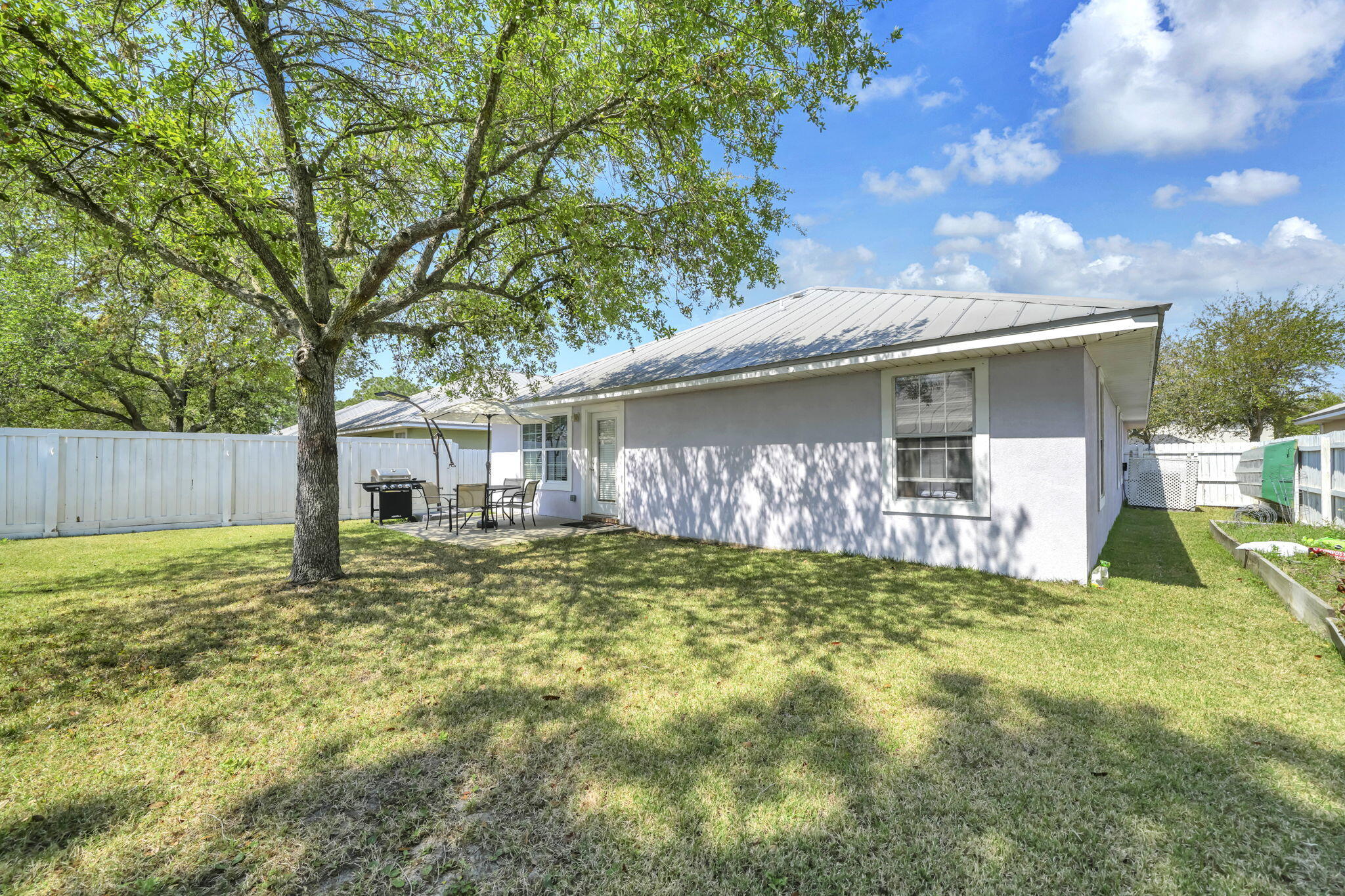 119 Red Bay Court Santa Rosa Beach, FL 32459 - Photo 34 of 36 a backyard of a house with table and chairs