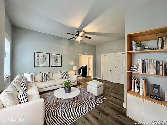 a view of a room with wooden floor and a ceiling fan