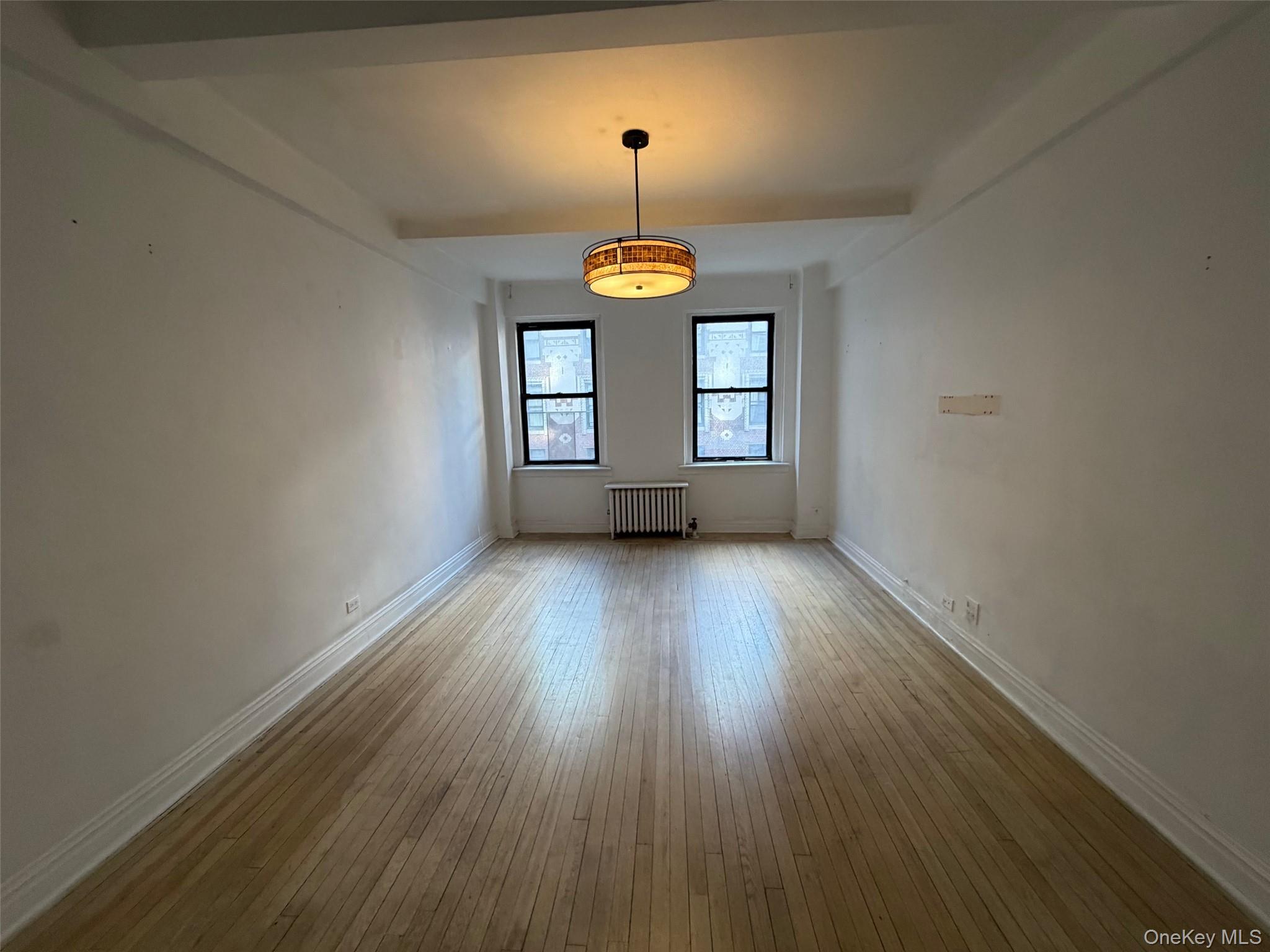 142 East 49th Street, Unit 8A Manhattan, NY 10017 - Photo 4 of 12 a view of a room with wooden floor and window