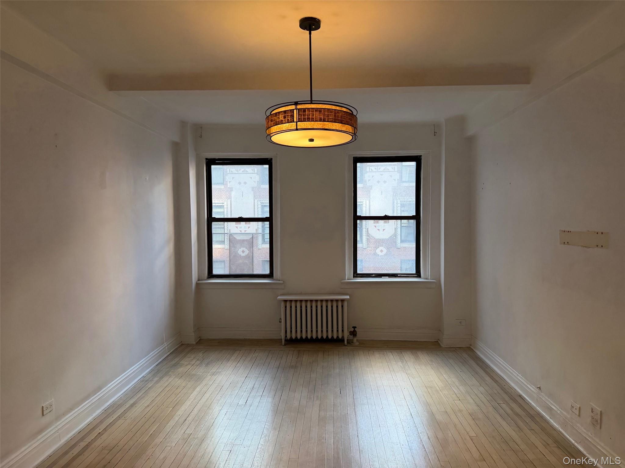 142 East 49th Street, Unit 8A Manhattan, NY 10017 - Photo 5 of 12 a view of an empty room with wooden floor and window